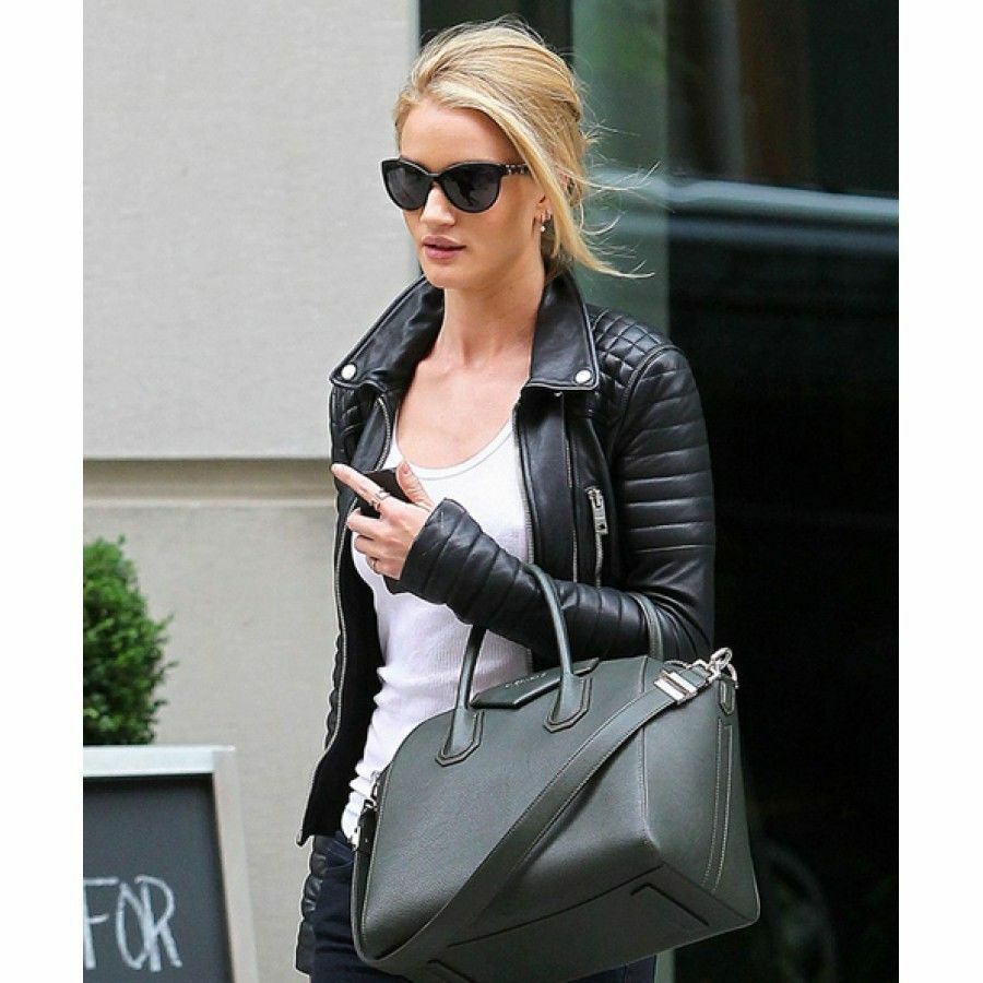 Elegant woman in chic black leather jacket checking her phone, featuring quilted details and paired with a casual white tee and sunglasses.